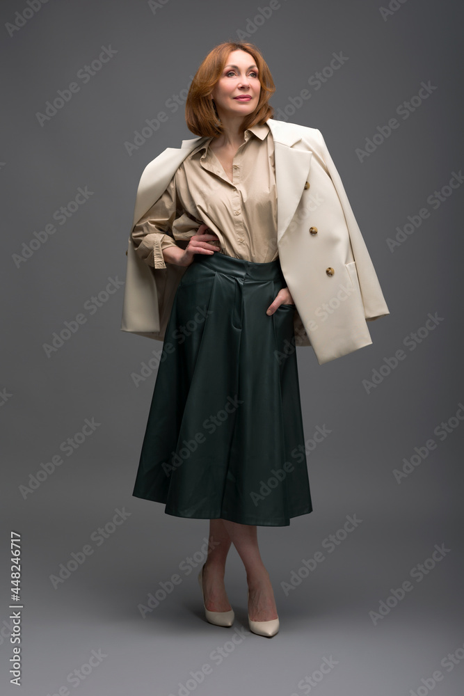 full length portrait of a fashionable aged woman isolated on grey