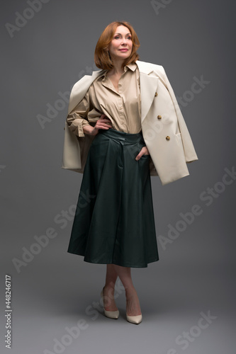 full length portrait of a fashionable aged woman isolated on grey