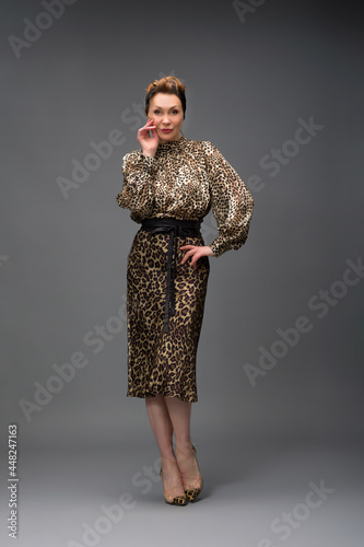 full length portrait of a fashionable aged woman isolated on grey