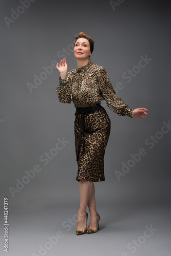 full length portrait of a fashionable aged woman isolated on grey