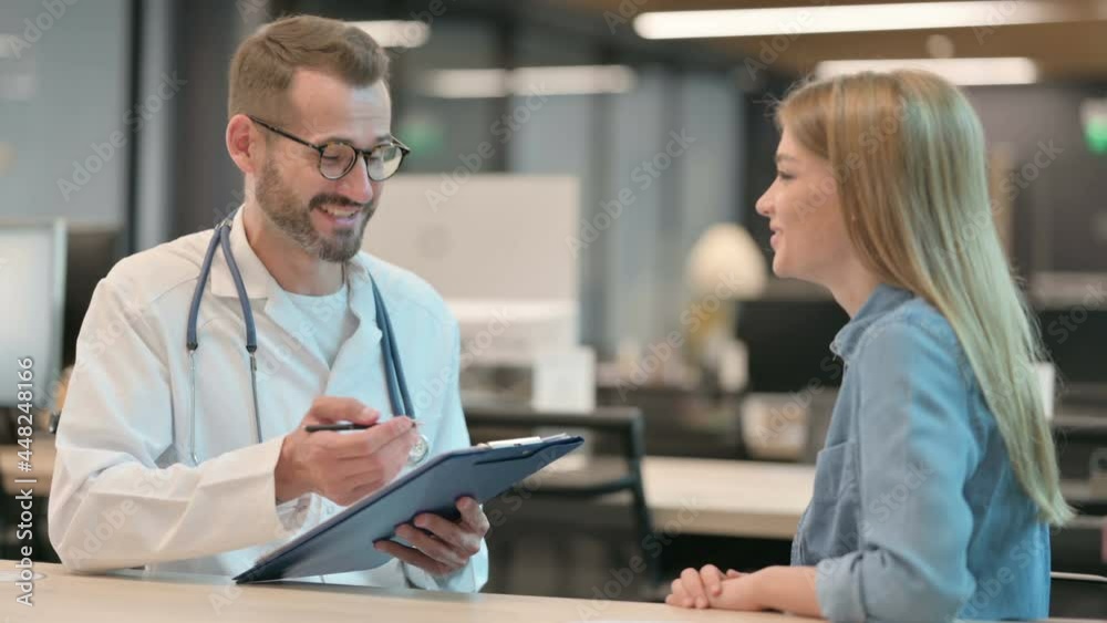 Positive Middle Aged Doctor Talking to Female Patient Positive Middle Aged Doctor Talking to Female Patient