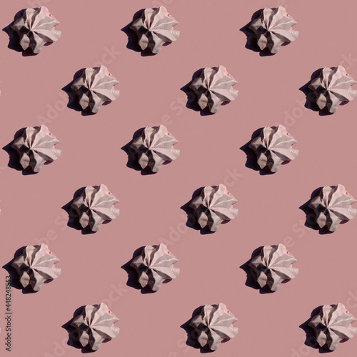 Pattern from meringues with shedow as a man profile on pink background photo