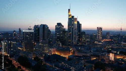 Frankfurt am Main Skyline and skyscrapers city lights cinematic panorama drone aerial fly away shot sunset evening photo