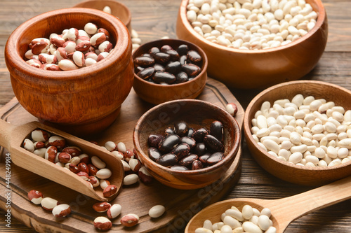 Different types of beans on wooden background