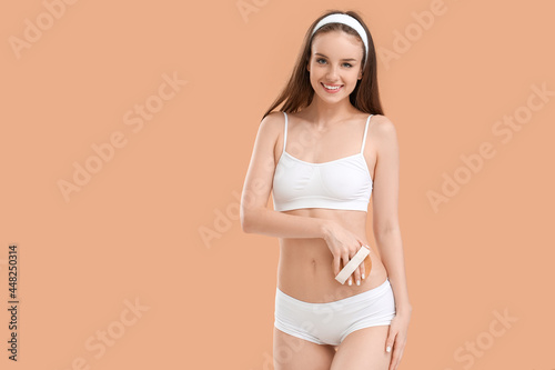 Beautiful young woman with massage brush on color background © Pixel-Shot
