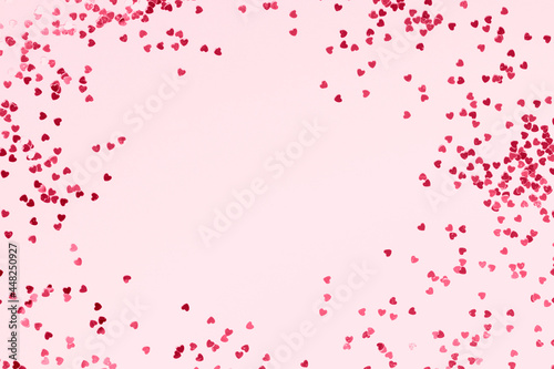 Pink pastel background with pink glittering hearts. Place for your text.