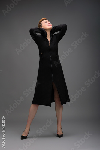 full length portrait of a fashionable aged woman isolated on grey