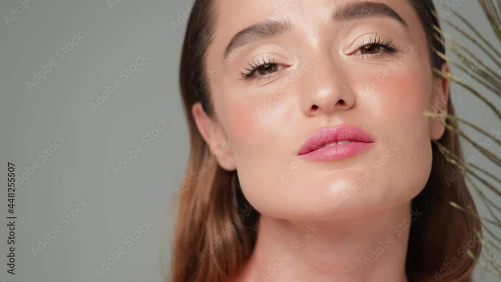 Beautiful Young Woman with Clean Fresh Skin standing over light grey background Beautiful Young Woman with Clean Fresh Skin standing over light grey background