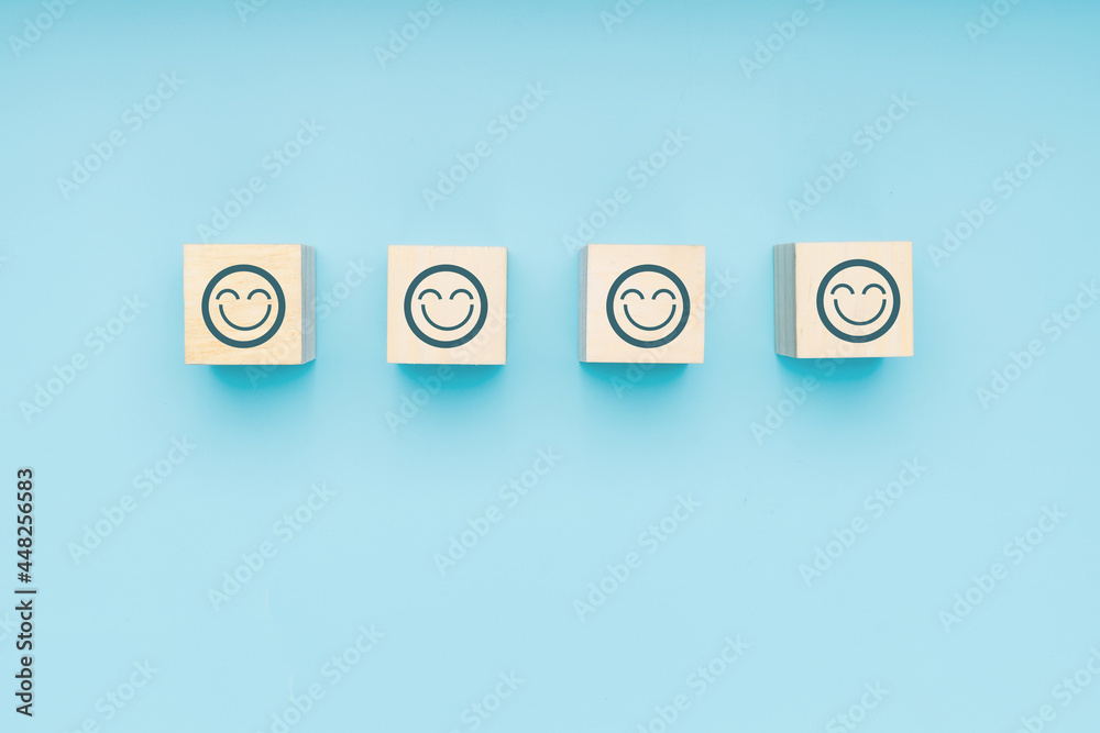 face of smile and pride for impressive service wood block on soft blue background, excellent, good emotion and perfect feedback concept face of smile and pride for impressive service wood block on soft blue background, excellent, good emotion and perfect feedback concept
