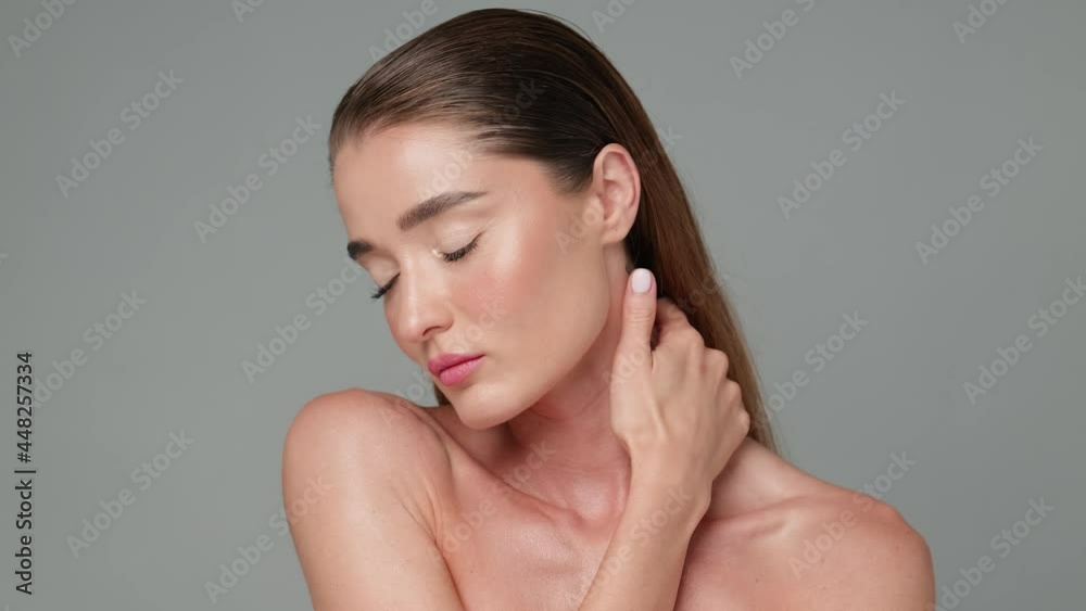 Beautiful Young Woman with Clean Fresh Skin standing over light grey background Beautiful Young Woman with Clean Fresh Skin standing over light grey background