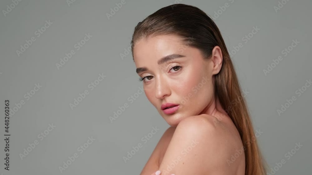 Beautiful Young Woman with Clean Fresh Skin standing over light grey background Beautiful Young Woman with Clean Fresh Skin standing over light grey background