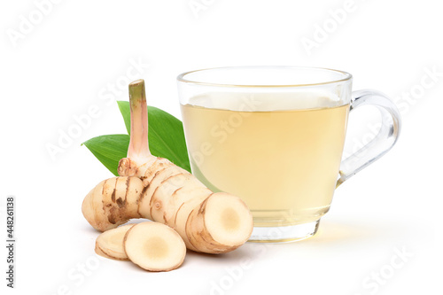 Galangal herbal beverage with fresh rhizomes slices solated on white background.