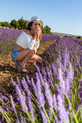 Wallpaper Mural A beautiful woman crouched down in a blooming lavender field. She covers her mouth with both hands surprised by something. Summer happiness concept. Torontodigital.ca