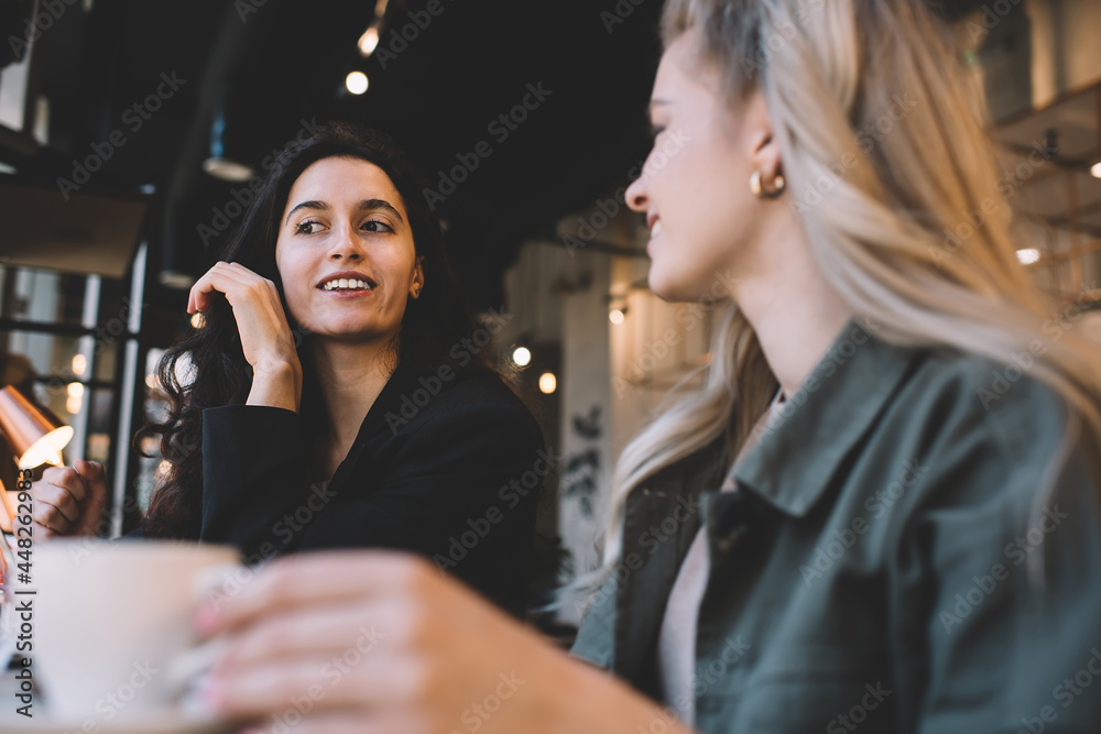 Happy women chatting while drinking coffee in lounge Happy women chatting while drinking coffee in lounge