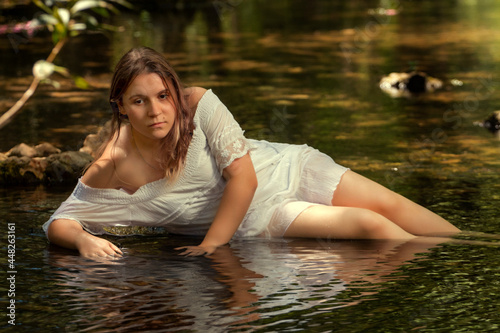 woman with white dress near stream of water