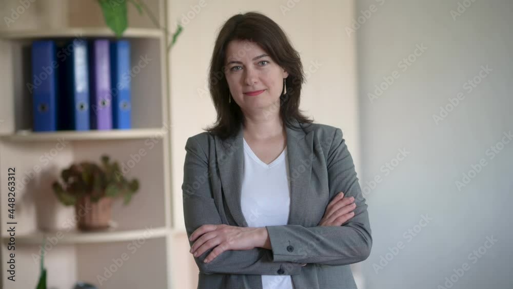 Beautiful middle aged adult business woman looking at camera stand in office. Happy confident lady, attractive senior female professional coach. Beautiful middle aged adult business woman looking at camera stand in office. Happy confident lady, attractive senior female professional coach.