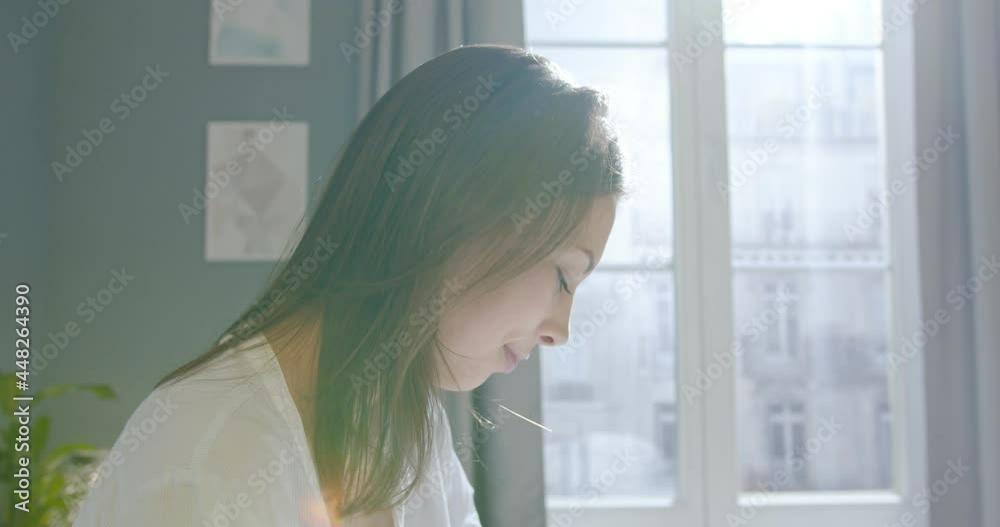 Close up of Caucasian beautiful young female resting at home sitting in bed awake after sleeping and drinking coffee or tea in the morning looking in window meeting new day. Home concept Close up of Caucasian beautiful young female resting at home sitting in bed awake after sleeping and drinking coffee or tea in the morning looking in window meeting new day. Home concept