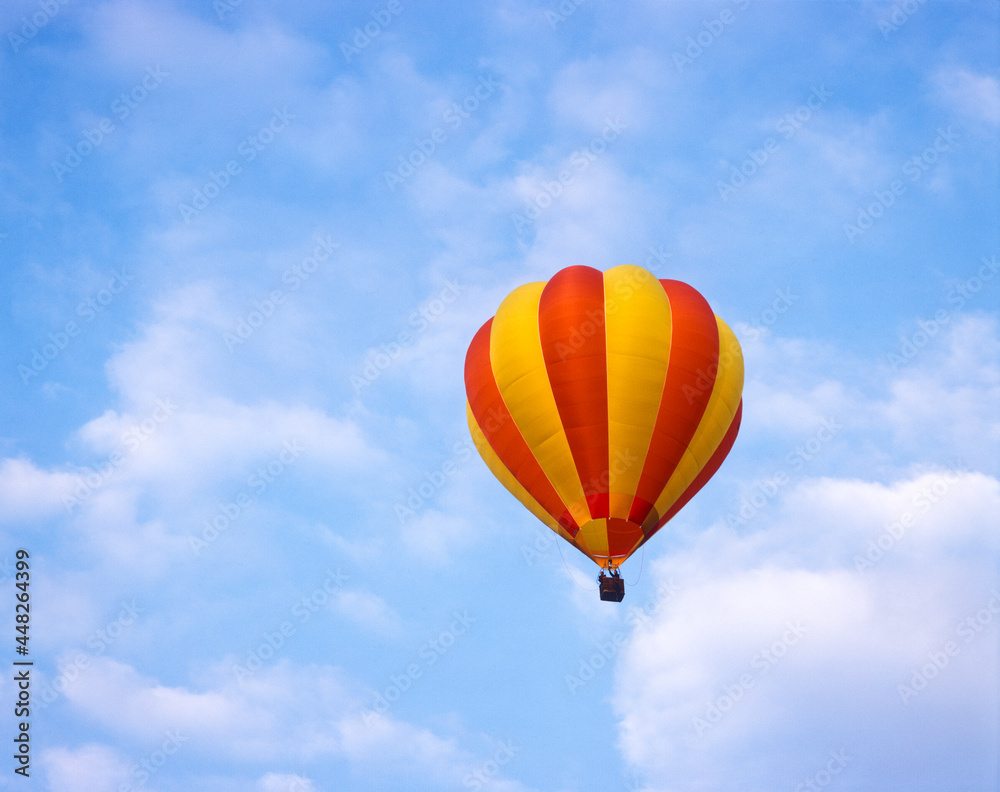 Obraz premium Red and yellow hot air balloon in a blue sky