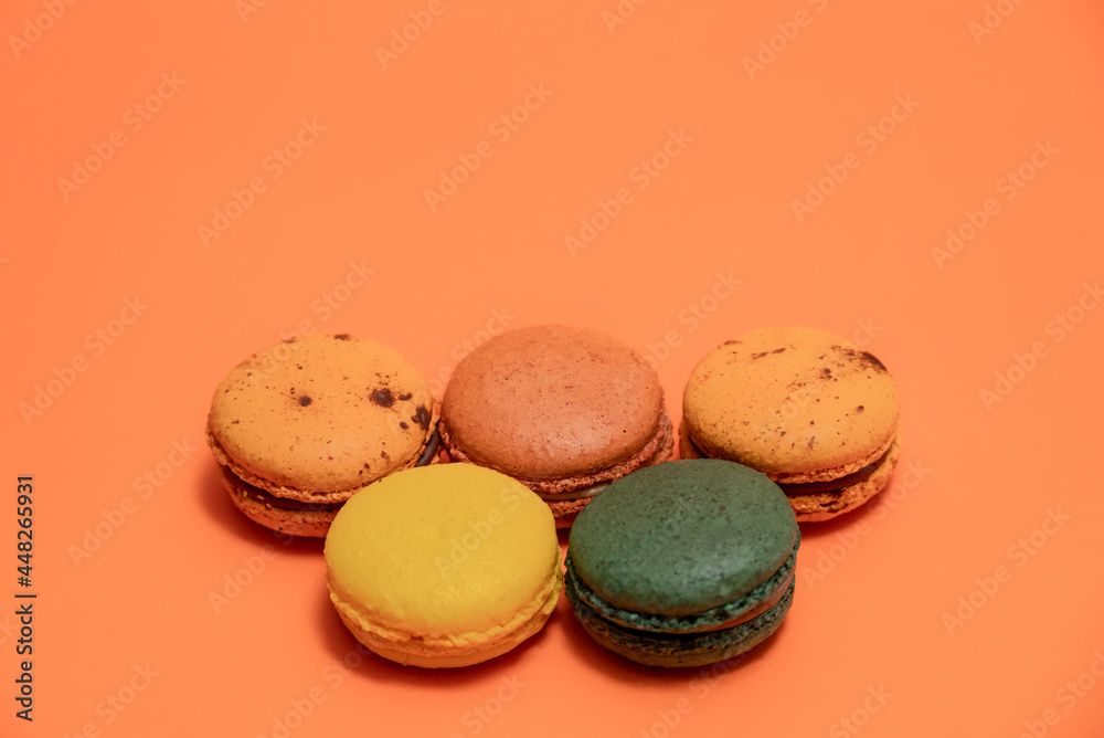 Fototapeta premium Close up of macaroons on an orange background