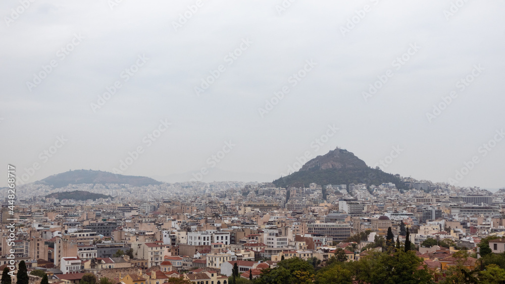 View on mount Lycabettus and Athens old city center with white buildings architecture in gray foggy day from Areopagus - Hill near Acropolis