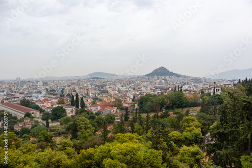 View on mount Lycabettus and Athens old city center architecture in vivid greenery in gray foggy day from Areopagus - Hill near Acropolis