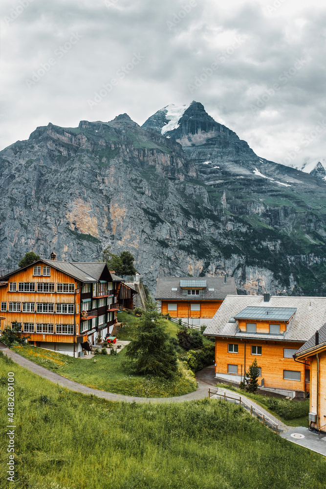 Traditional chalet and road in Swiss Alps. Switzerland, Jungfrau. Cozy small village in mountains. Beautiful landscape, Europe.