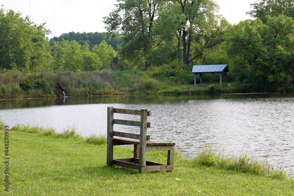 The empty wood bench on the lake shore in the park. The empty wood bench on the lake shore in the park.