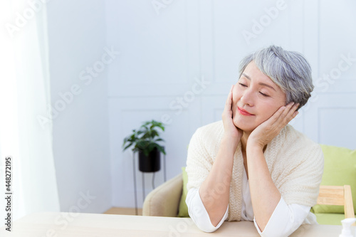 The beauty Senior Asian woman with grey hair enjoys doing skin care.