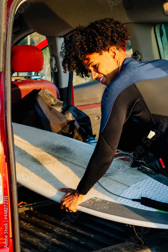 Photography Young African American man with a surfboard in the motorhome
