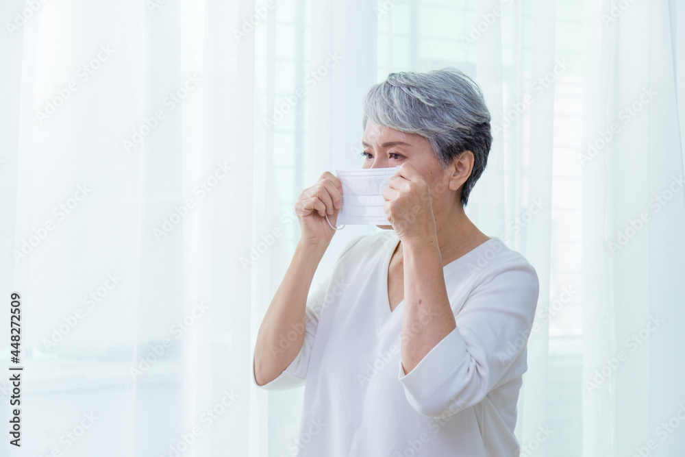 Asian senior woman suffer from cough with face mask protection