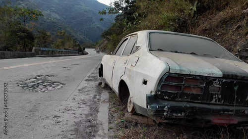 LA PAZ, BOLIVIA - Jul 12, 2021: A timelapse of an abandoned Mazda vehicle on the Coroico-Caranavi road in La Paz, Bolivia