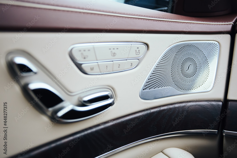 Car inside. Interior of prestige modern car. Climate control, hi-end sound speakers, seat memory, door lever