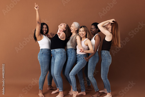 Side view of women of different body types dancing together and having fun in the studio photo
