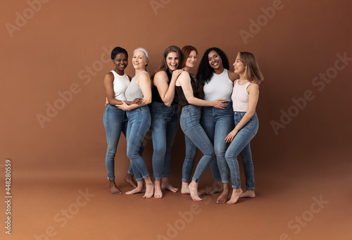 Foto Group of multi-ethnic women in casuals posing together against a brown backgroun