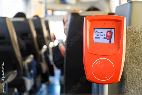 Orange ticket validation machine on a modern public transport bus photo