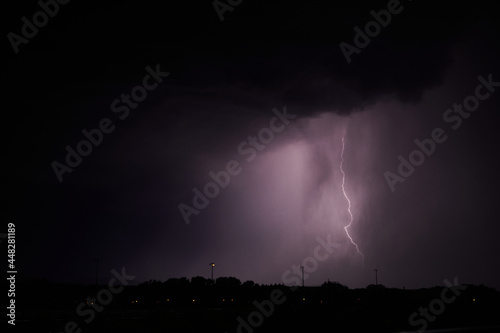 Fototapeta Naklejka Na Ścianę i Meble -  Gewitter. Blitz in der Nacht erhellt Wolken, Silhouette einer Stadt hebt sich ab.