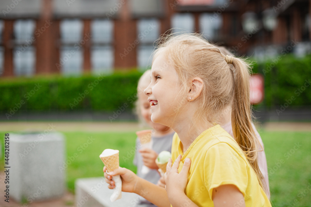 Three kids eating ice cream on hot summer day. Siblings walking outside and enjoying ice cream Three kids eating ice cream on hot summer day. Siblings walking outside and enjoying ice cream