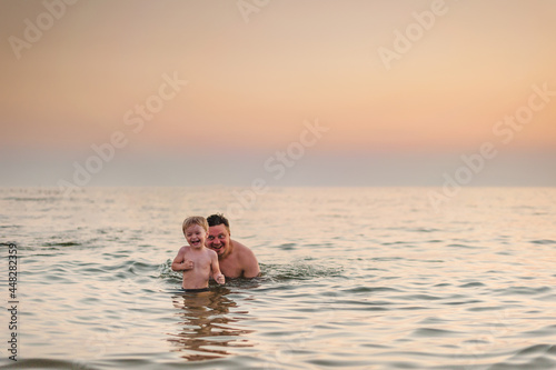 dad and son have fun swimming in the sea at sunset in the summer © sun_house_ann