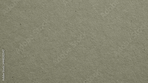 The surface of gray cardboard. Paper texture with cellulose fibers. Paperboard wallpaper. Background with a generic gray tint. Textured glamorous and graceful backdrop. Top-down. Macro