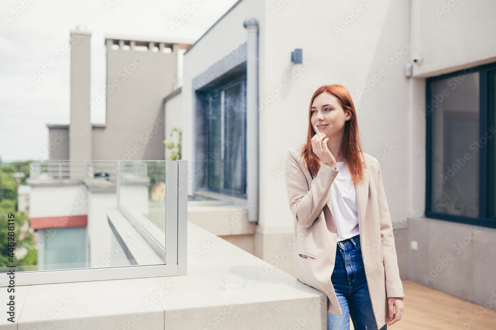 Woman businessman smokes on the balcony, office center stress and fatigue from work