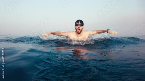 Giovane ragazzo nuota a delfino nel mare photo