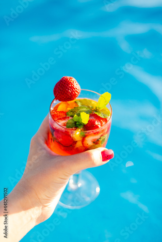 person holding a cocktail in the pool