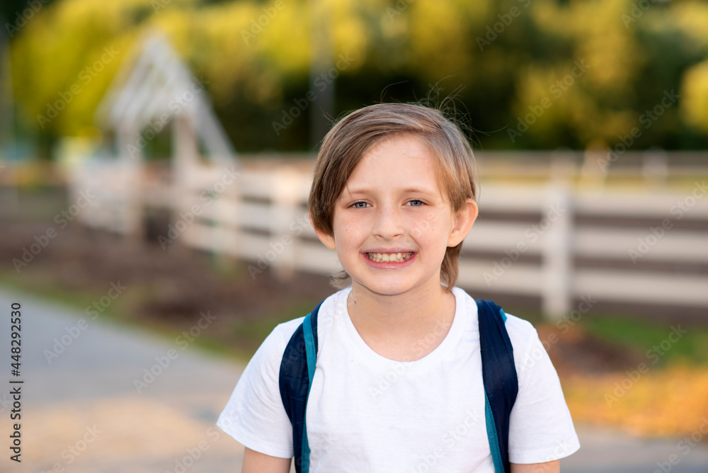 portrait of a happy smiling boy standing at the racetrack on the farm portrait of a happy smiling boy standing at the racetrack on the farm