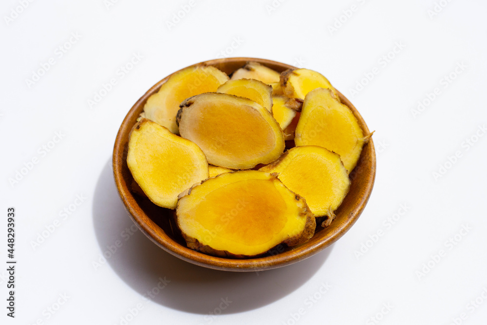 Phlai slices, Cassumumr ginger or zingiber montanum in wooden bowl on white background.
