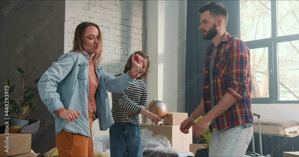 Cheerful family in new home. Fun happy parents dancing together with girl child after buying and moving in apartment. Cheerful family in new home. Fun happy parents dancing together with girl child after buying and moving in apartment.