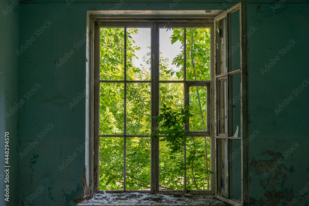 Obraz premium A window in a crumbling building. Inside view.