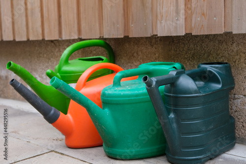 Multi coloured watering cans in a garden