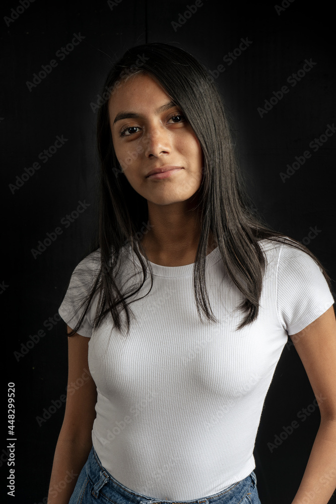 Medium short portrait of a beautiful smiling latin woman in white shirt on black background. Medium short portrait of a beautiful smiling latin woman in white shirt on black background.