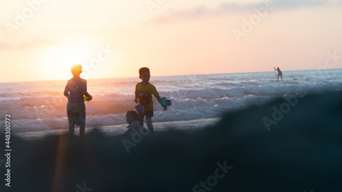people walking on the beach at sunset