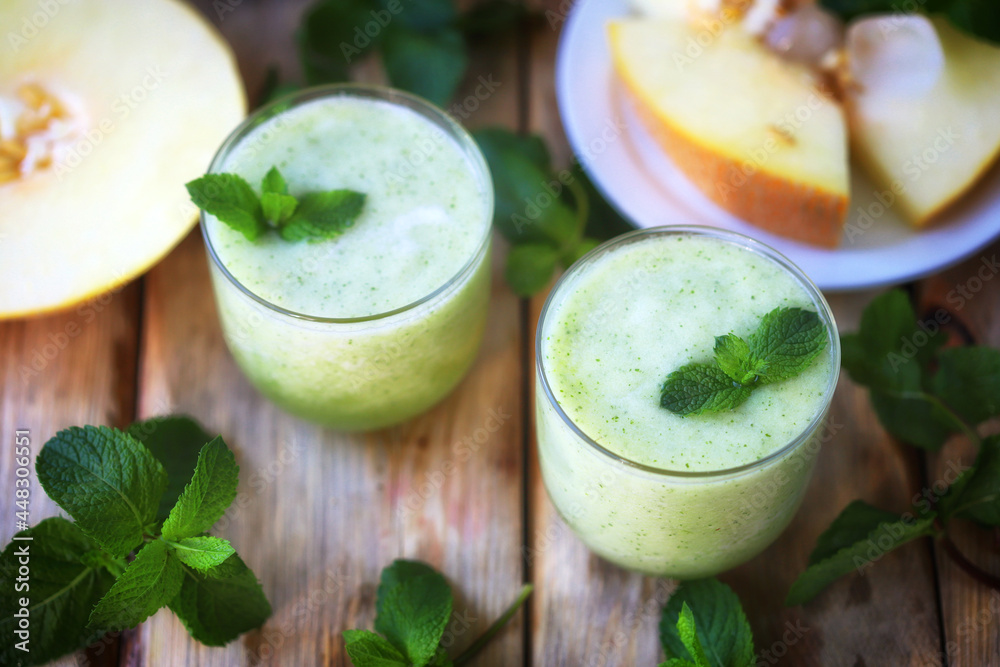 Smoothie melon mint in glasses on a wooden surface. Summer refreshing drink. Detox drink.